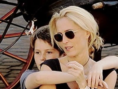 Oscar Griffiths is hugging Gillian Anderson from behind.